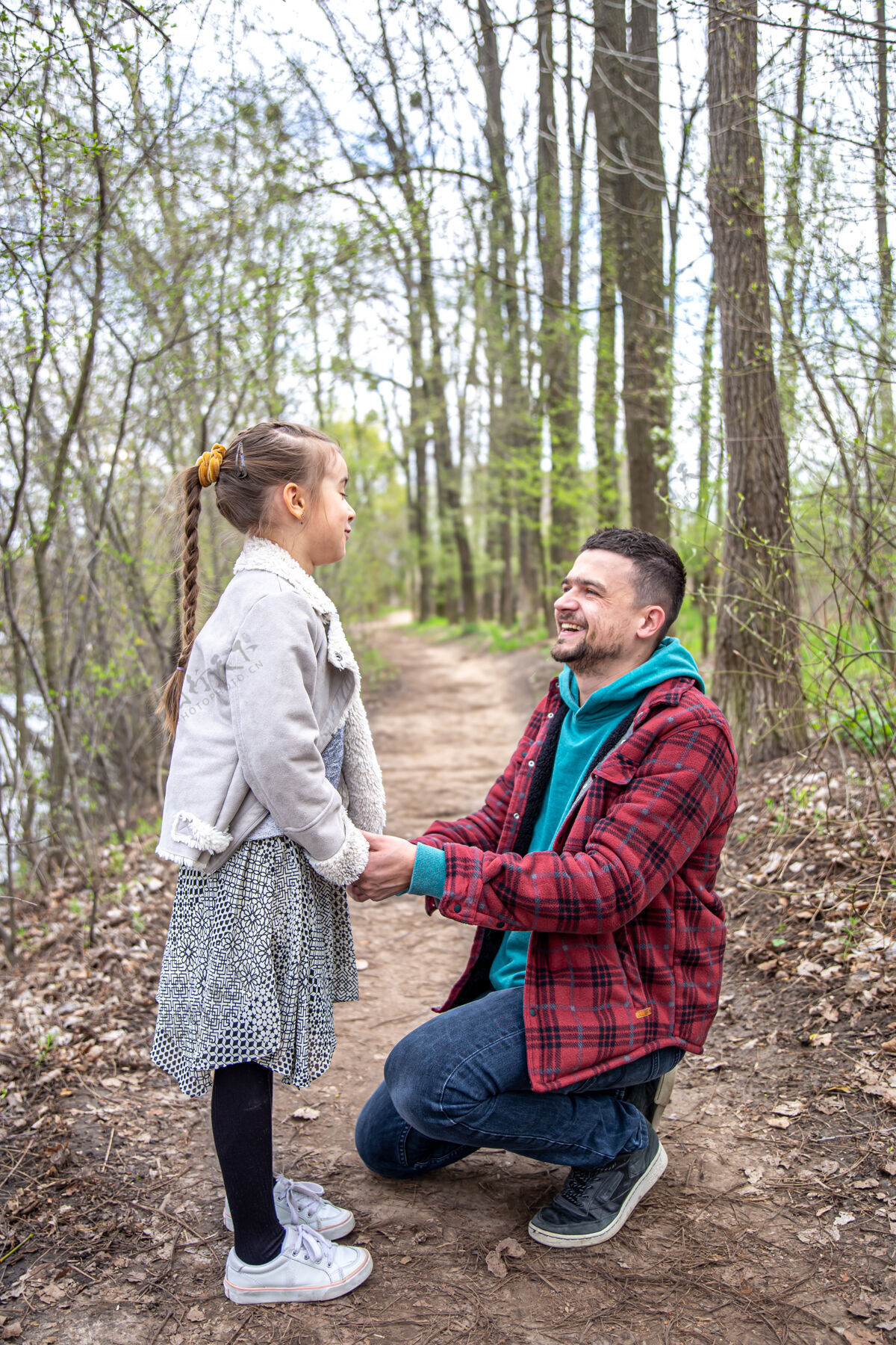 关心一个小女孩牵着手在树林里和爸爸散步托儿远足跪下