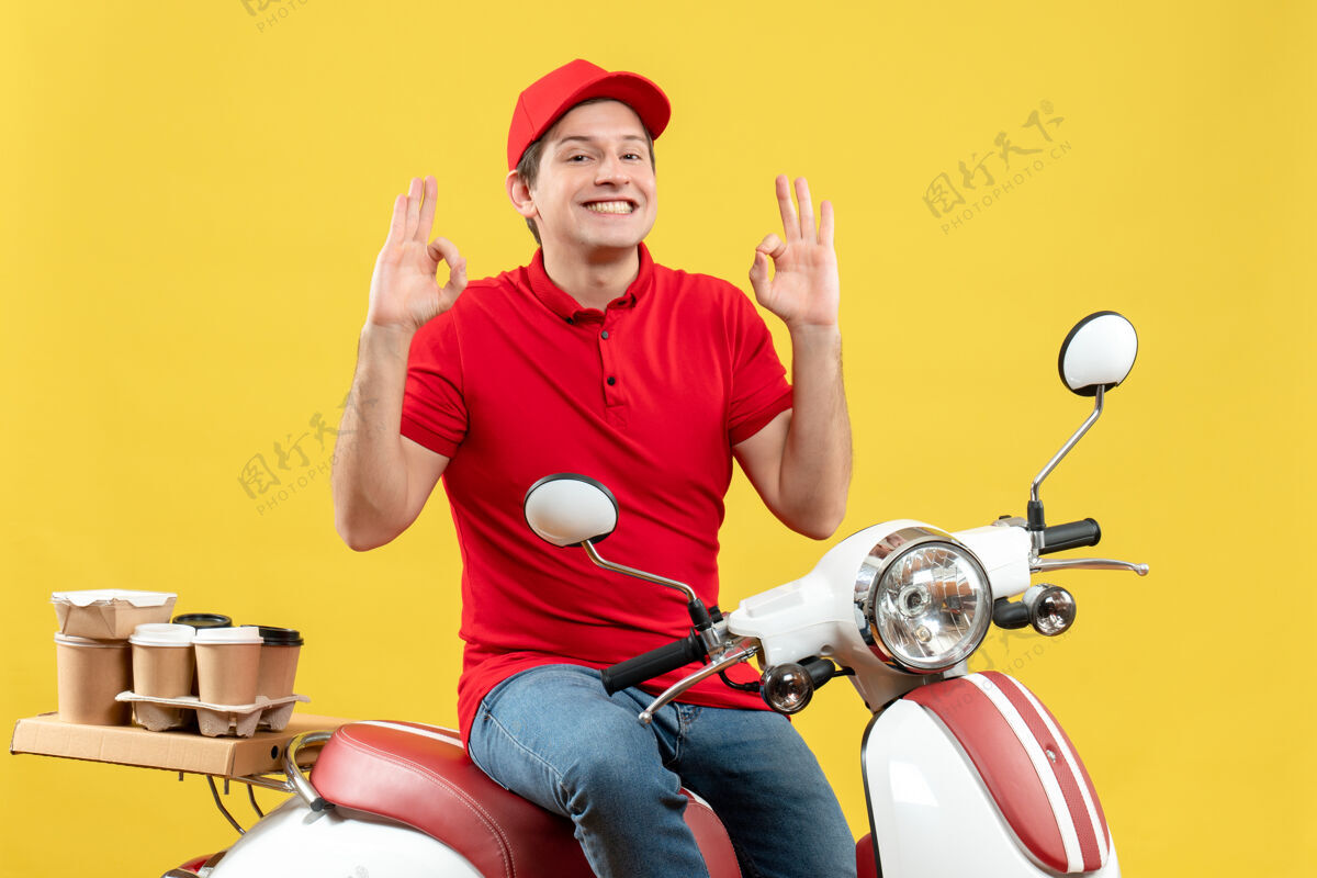 年轻人正面是一个自信的年轻人 穿着红色上衣 戴着帽子 一边发订单 一边戴着黄色背景的眼镜背景黄色帽子