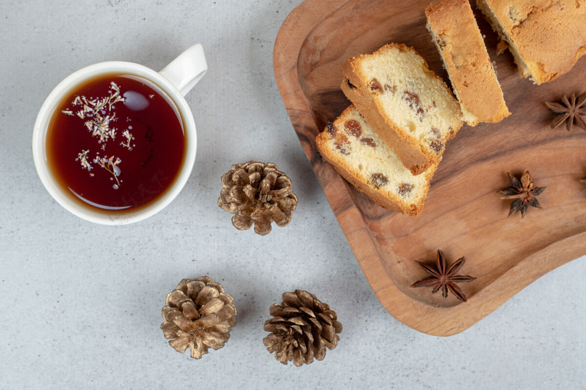 茴香美味的松饼加葡萄干和一杯茶放在木板上松饼食物星星
