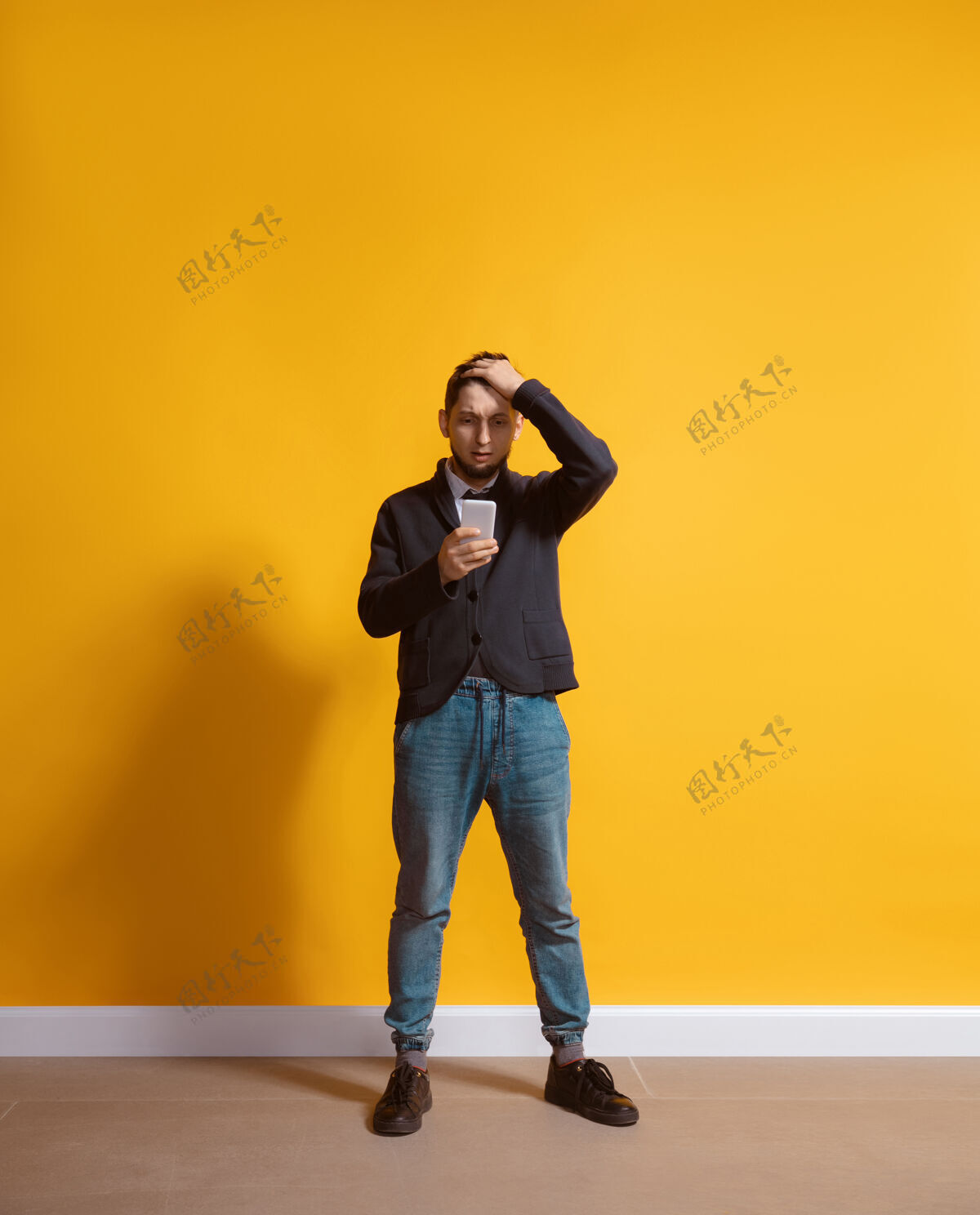 年轻年轻的白人男子用智能手机全身肖像隔离在黄色的墙壁手机帅气使用
