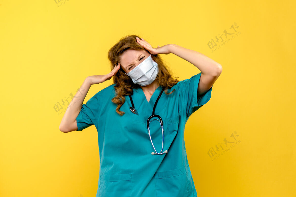 头发黄色墙壁上戴着面具的女医生的正视图模特面具人