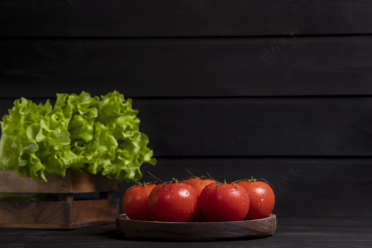 圆形一块木板上放满了新鲜的红色多汁西红柿和生菜沙拉高质量的照片新鲜多汁的有光泽