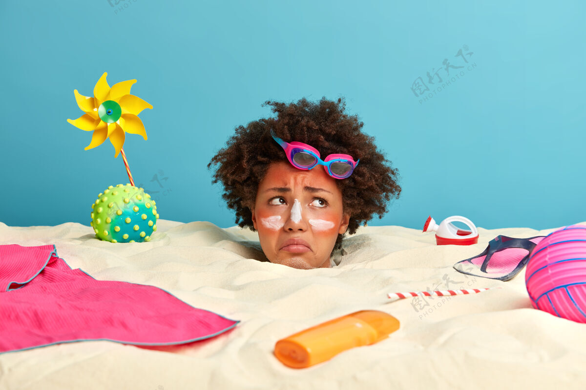 休息年轻女子头上涂着防晒霜 脸上围着沙滩饰品物品放松阳光