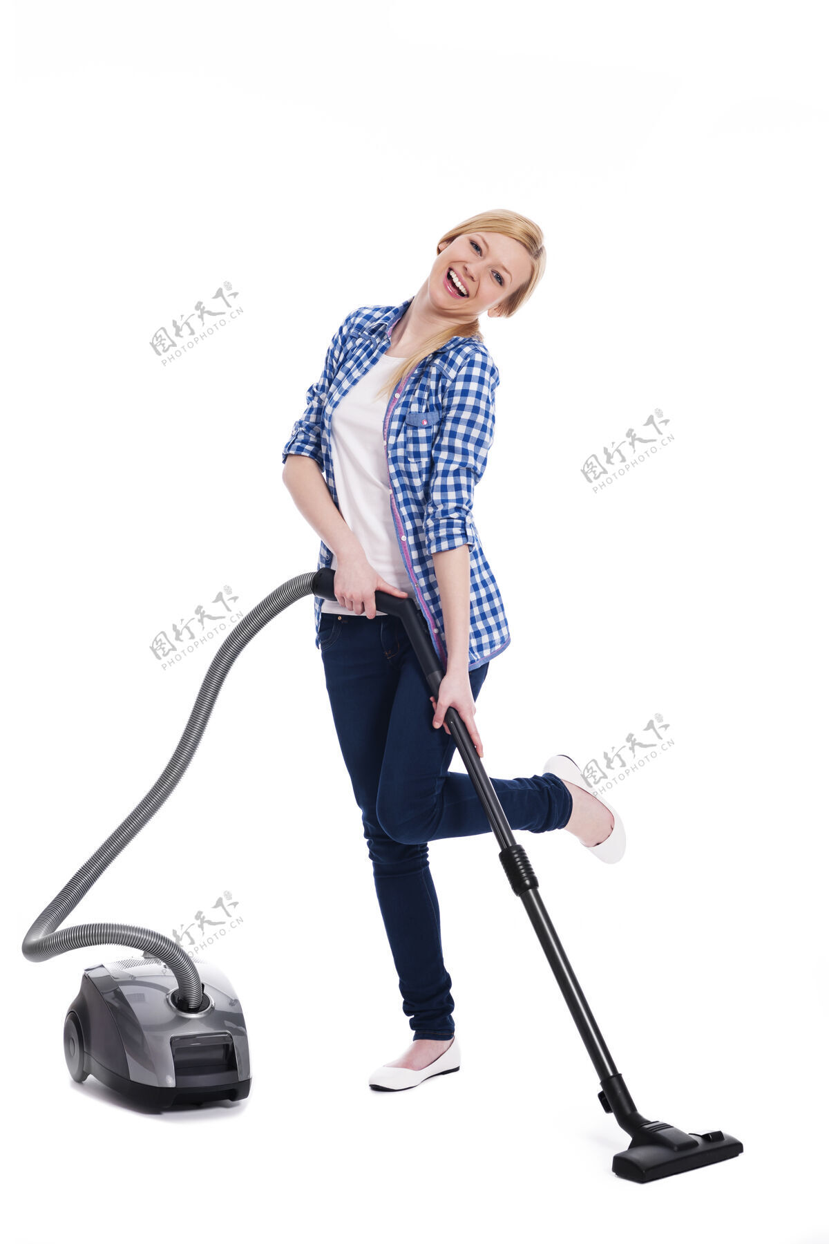 站立美丽微笑的女人在用吸尘器打扫地板家务家用设备清洁设备