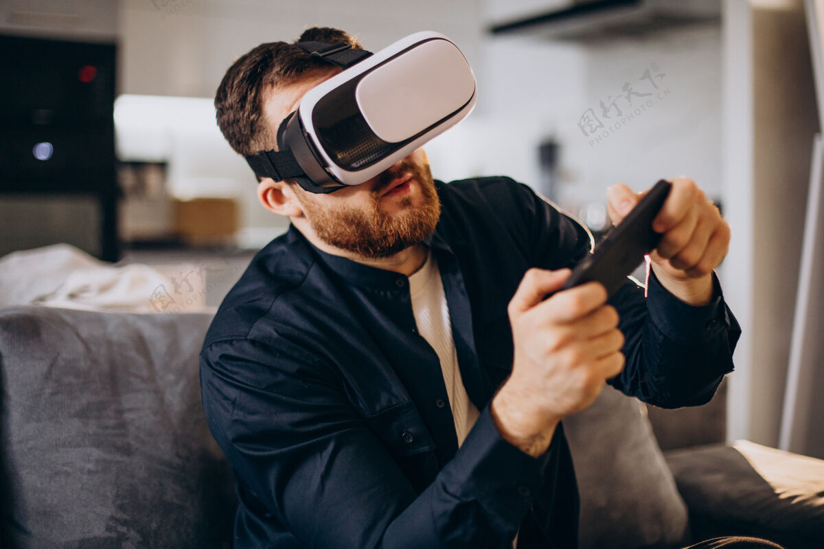 帅哥坐在家里使用虚拟现实的男人设备娱乐人