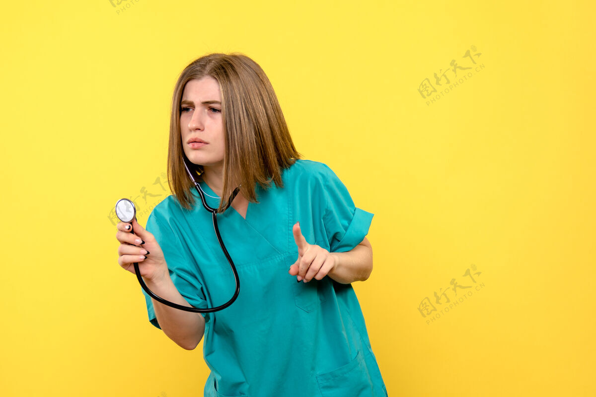情绪黄色墙上带眼压计的女医生的正视图护理医疗药品