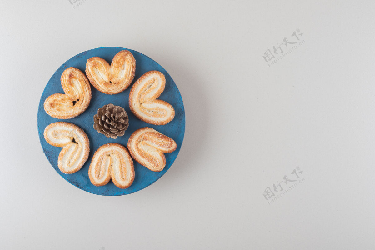 烤的松果被片状饼干包围在大理石背景的盘子里好吃的松树曲奇