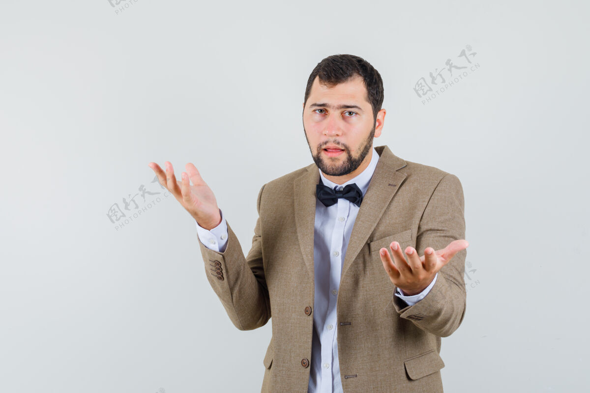 站着一个年轻人穿着西装 手拉手做着询问的姿势 看上去很困惑正面图西装质疑肖像