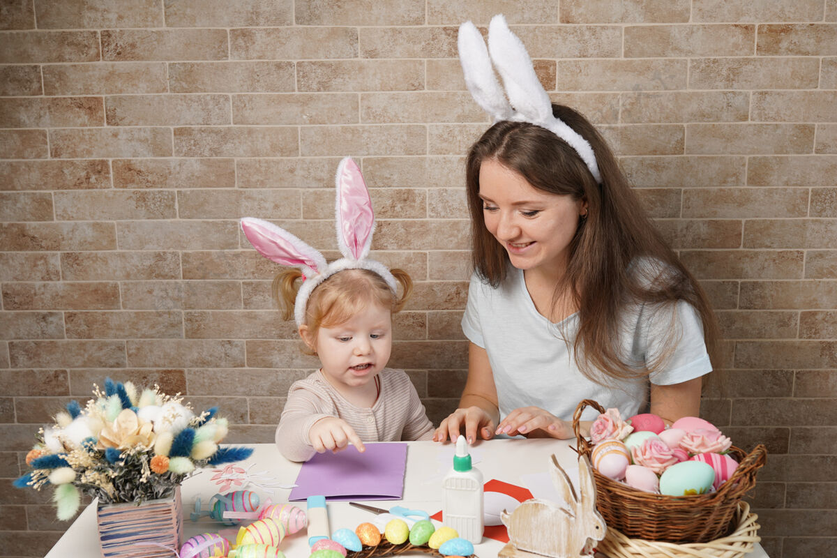 传统复活节 家庭 节日和孩子的概念-小女孩和母亲为复活节彩蛋特写兔子象征兔子