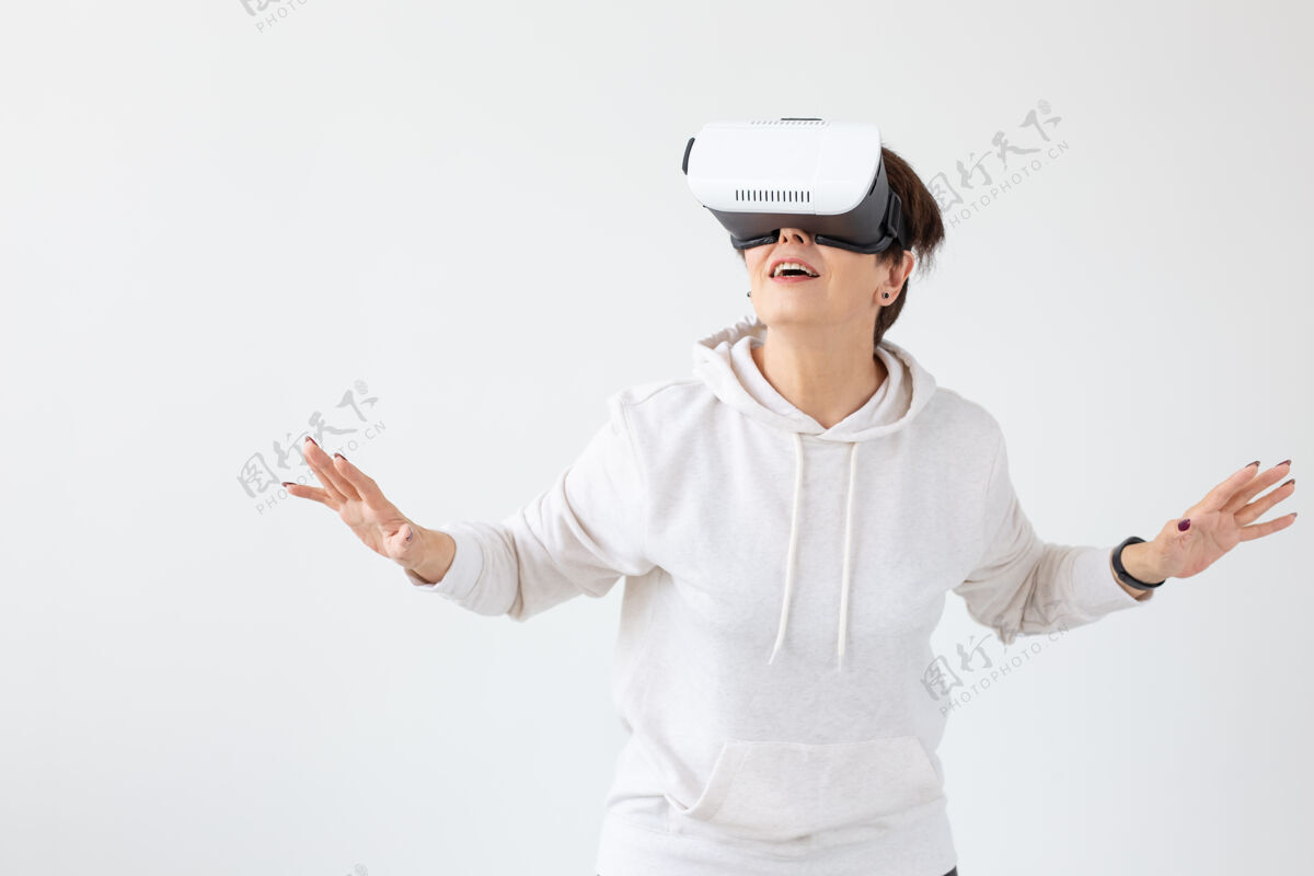 华丽不明身份的中年女子穿着一件轻便毛衣 戴着虚拟现实的眼镜玩着一个d游戏年轻中间梦幻