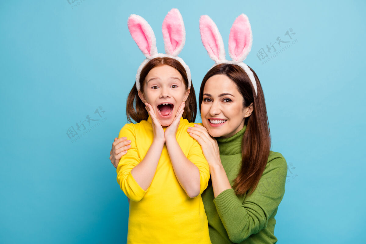 有趣漂亮迷人可爱惊艳开朗活泼的女孩妈妈妈妈妈妈妈妈戴着兔子耳朵玩得很开心隔着明亮生动的亮色鲜艳的蓝色兴奋孩子母性