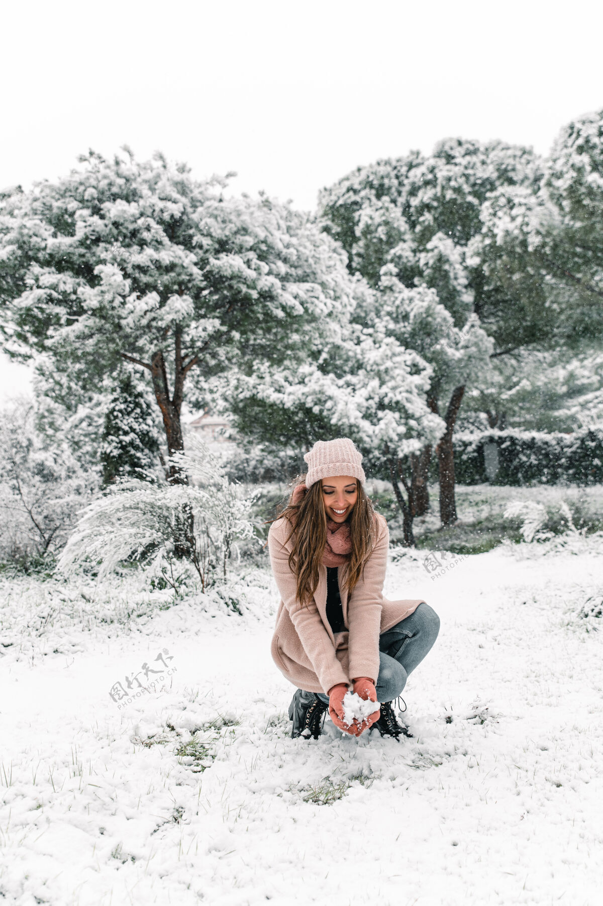 仙境快乐的女人穿着暖和的衣服坐在雪堆里的树林里 享受冬天的周末欢乐周末宁静