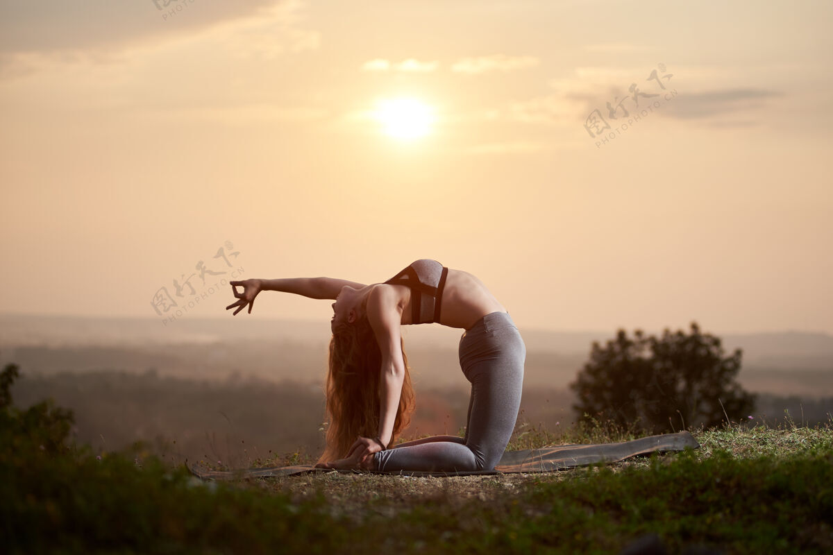 体操日落时分在户外练瑜伽的年轻女子日落体位法困难