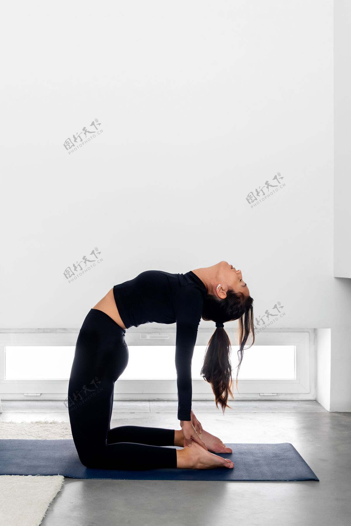 瑜伽在家练习瑜伽时练习骆驼姿势的女人运动体位健身