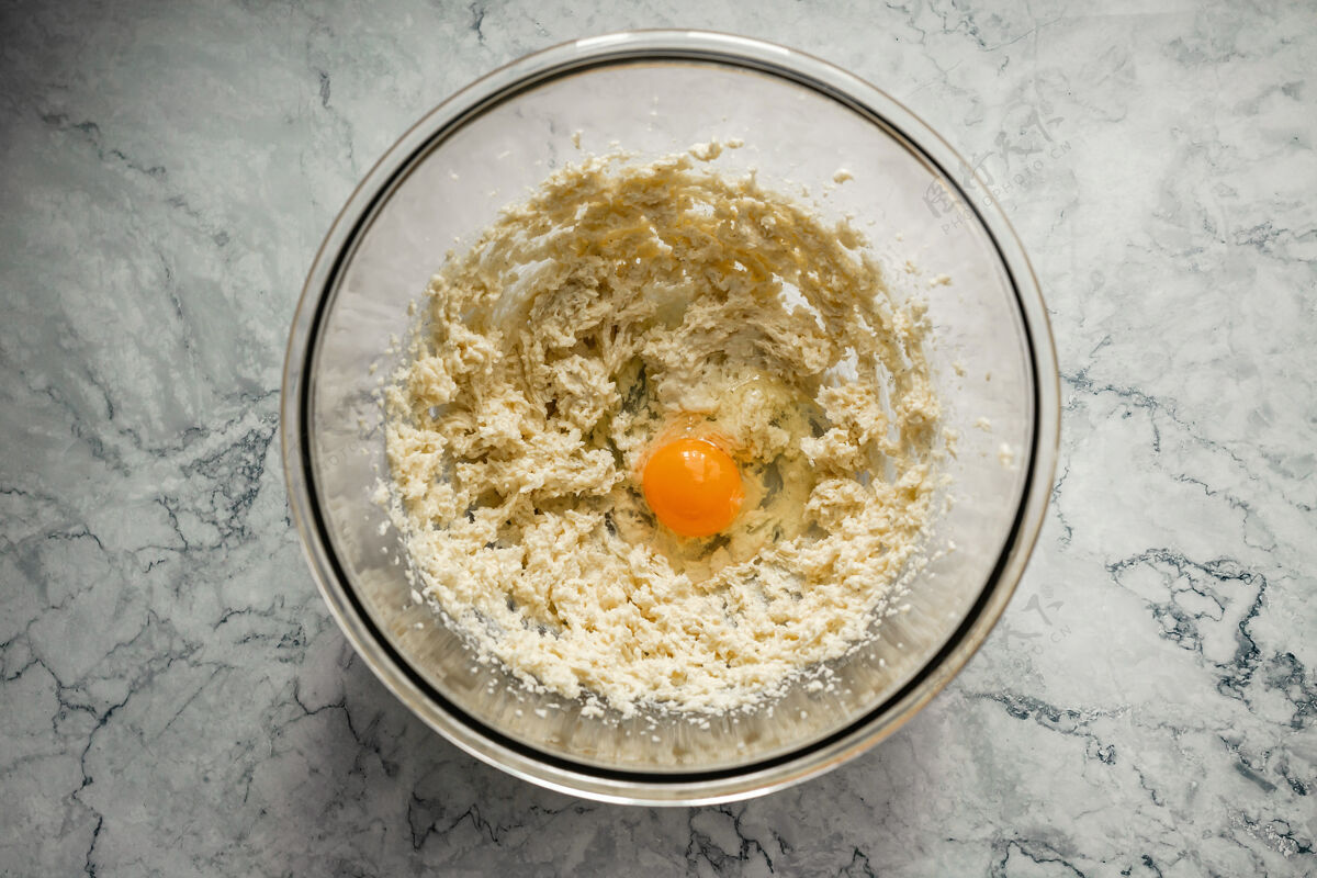 食物烤饼干黄油 糖和鸡蛋的混合物放在一个大玻璃碗里俯视水平照片混合香草大理石