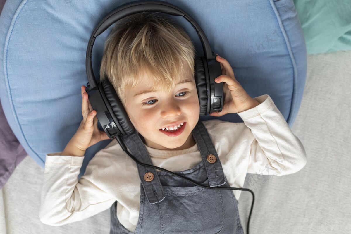 孩子顶视图男孩用耳机听音乐模特科技笑脸