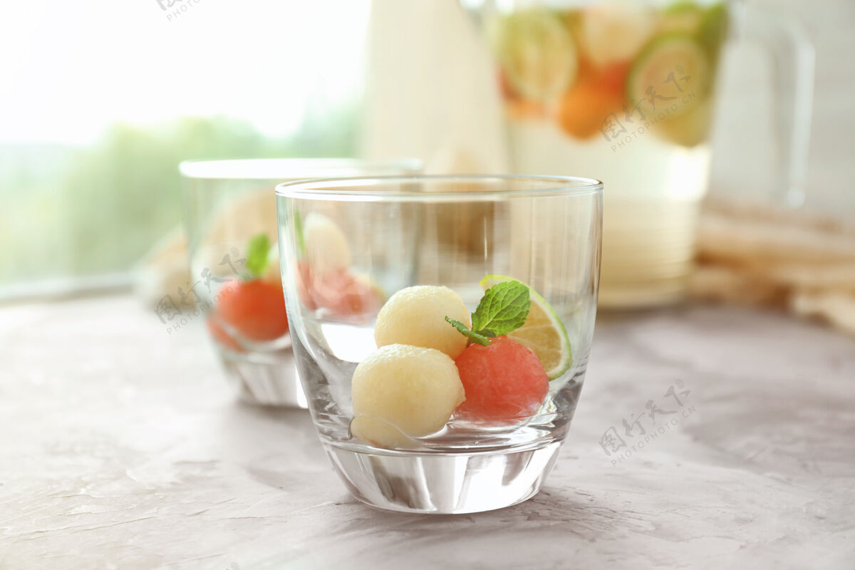西瓜桌上有甜瓜球饮料的玻璃杯素食者产品准备