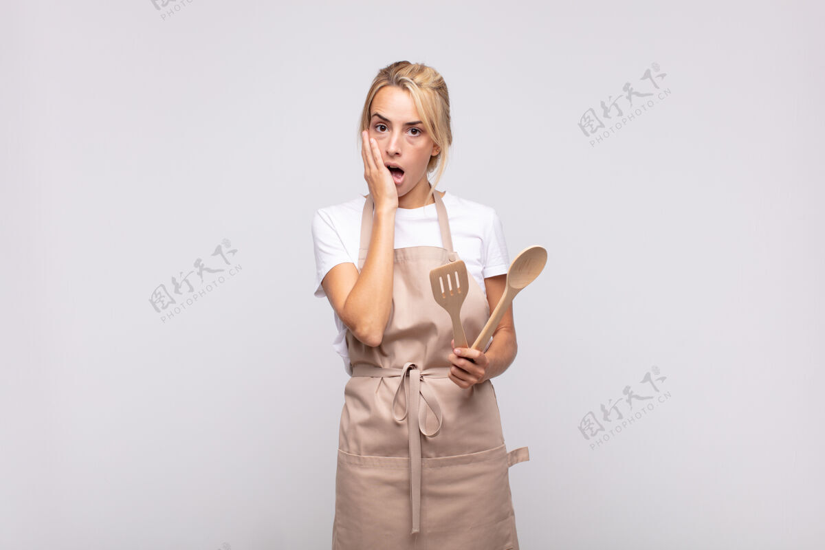 难以置信年轻的女厨师感到震惊和害怕 张大嘴巴 双手放在脸颊上 看起来很害怕开放肖像餐厅