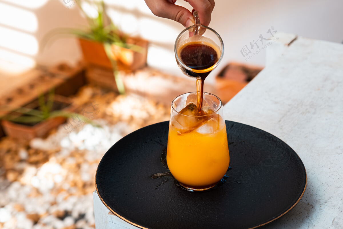 桌子木桌上放着一杯橙汁浓缩咖啡果汁鸡尾酒水果