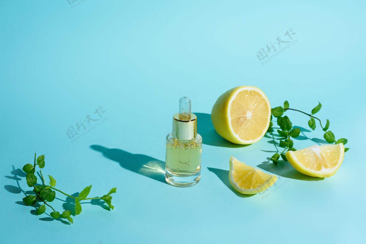 产品脸上的精华液用柑橘类水果柠檬和维生素c装在一个玻璃瓶中 用移液管在蓝色的背景上 这是家里自我护理皮肤的概念维生素面部有机
