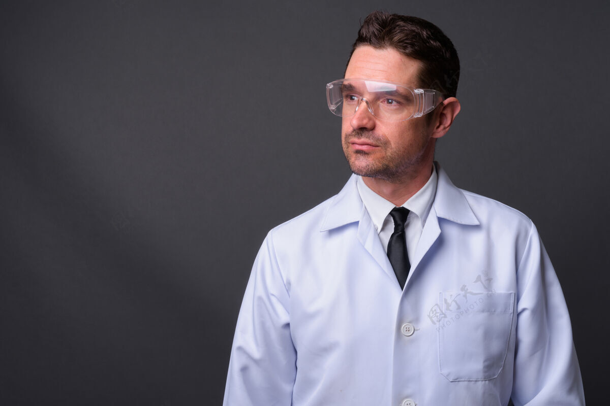 头部英俊的大胡子男人 医生 科学家 戴着防护眼镜 挡在灰色的墙上胡须科学家吸引力