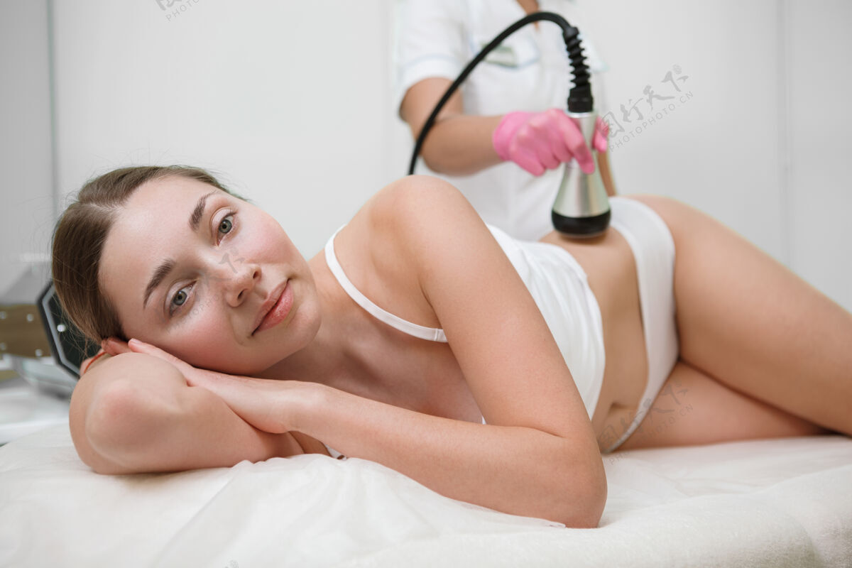 女人美女在美容诊所接受消脂硬件美容治疗按摩美容护理