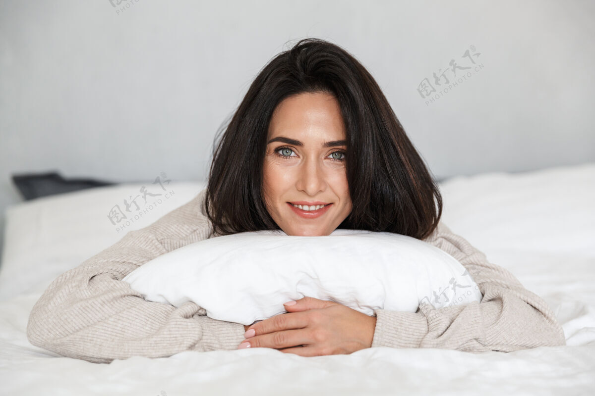 谎言图为30多岁的中年妇女微笑着 躺在床上 家里穿着白色亚麻布女士吸引亚麻布