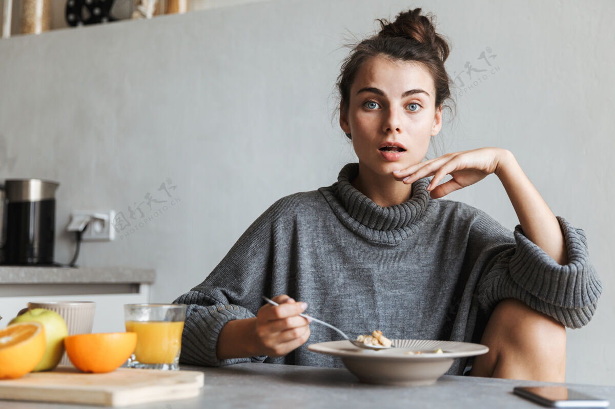 早餐坐在厨房里吃健康早餐的年轻漂亮女人美味信息女人