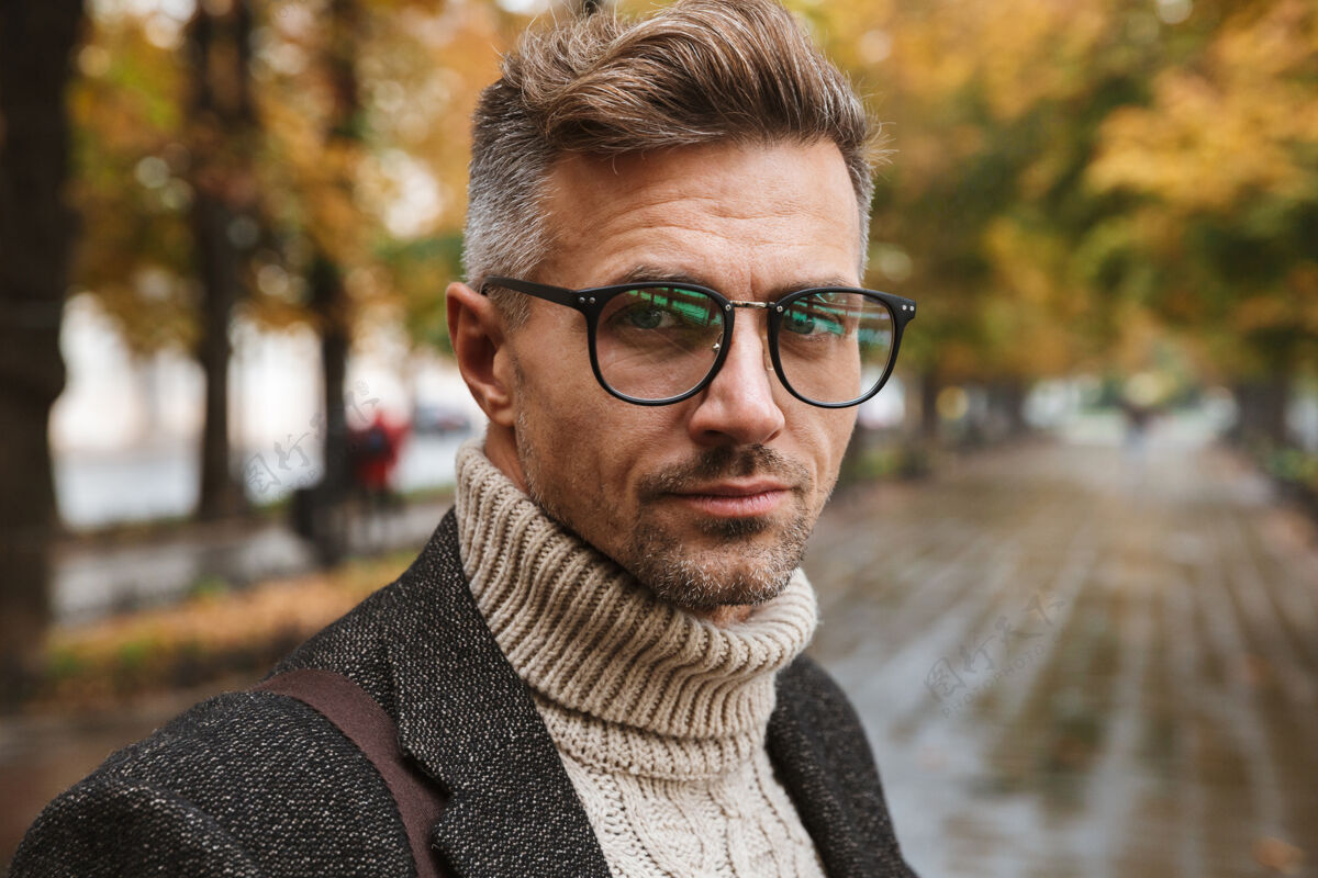 肌肉发达图为30多岁的成年男子戴着眼镜 在户外穿过秋天公园寒冷眼镜帅气