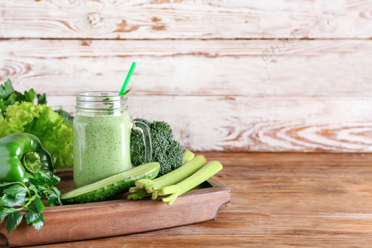 蔬菜一罐健康的冰沙和绿色蔬菜放在木头表面冰沙水果食物