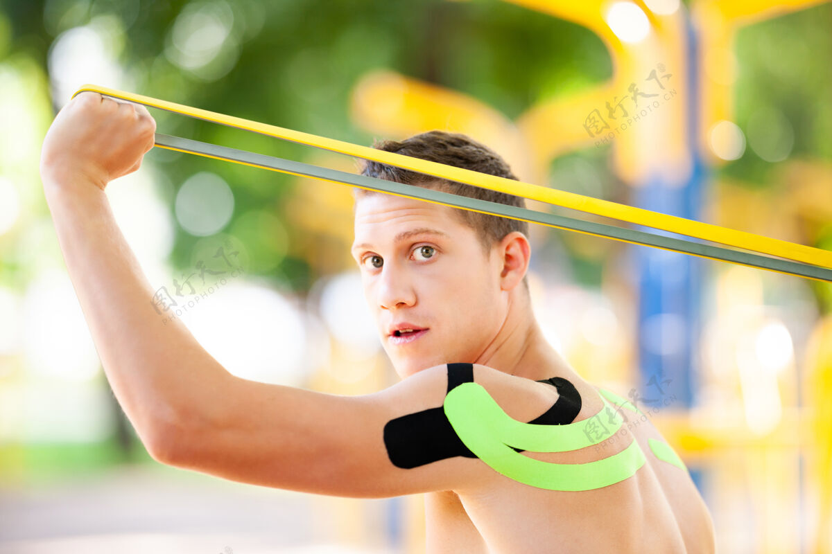康复裸体肌肉男训练与健身阻力带在公园和运动场的背景成人活动腹肌