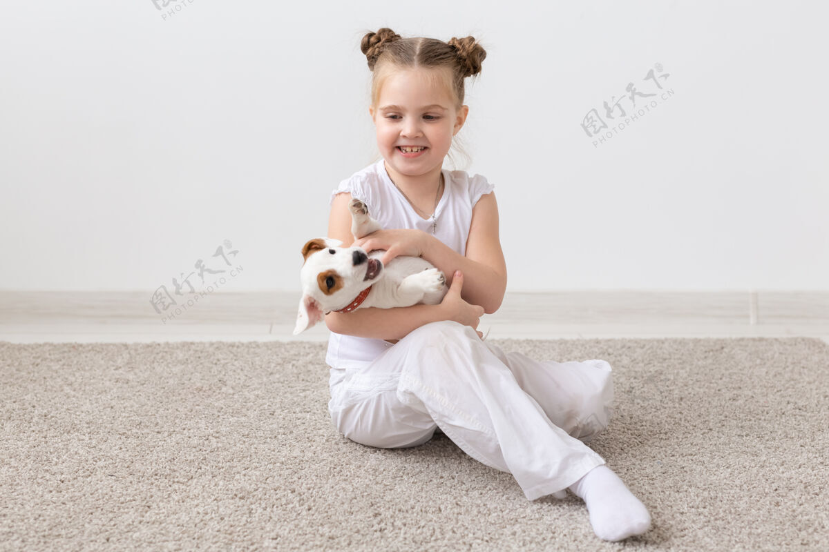 玩小女孩和小狗坐在地板上的画像狗衬衫宠物