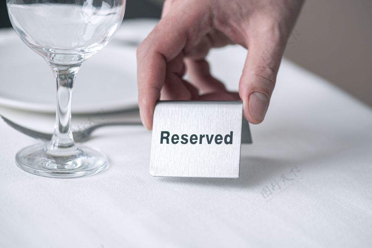 标语牌餐厅里 一个服务员拿着一块白桌布 桌子上留有文字的铁牌子餐厅标牌金属