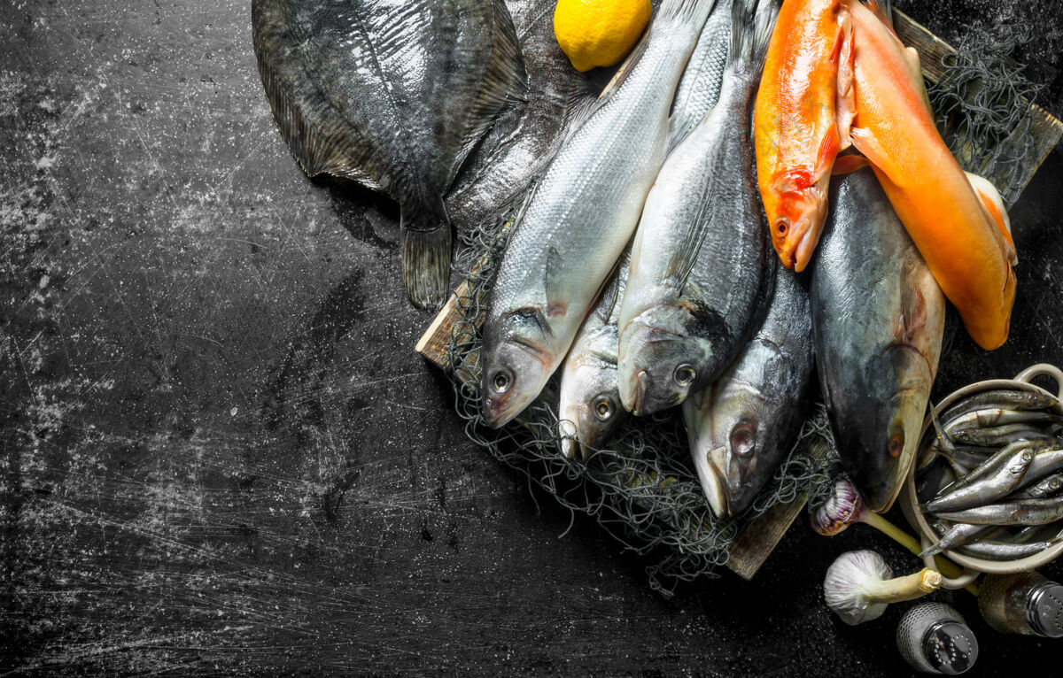 餐桌新鲜的生鱼放在盘子里 大蒜和香料放在乡村的桌子上金枪鱼健康配料