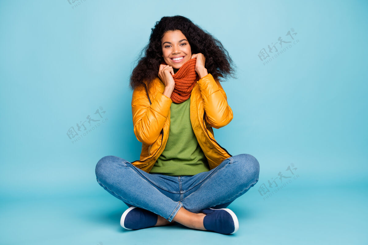 魅力美丽的黑皮肤女士坐在蓝色的背景触摸围巾非洲多国套头衫