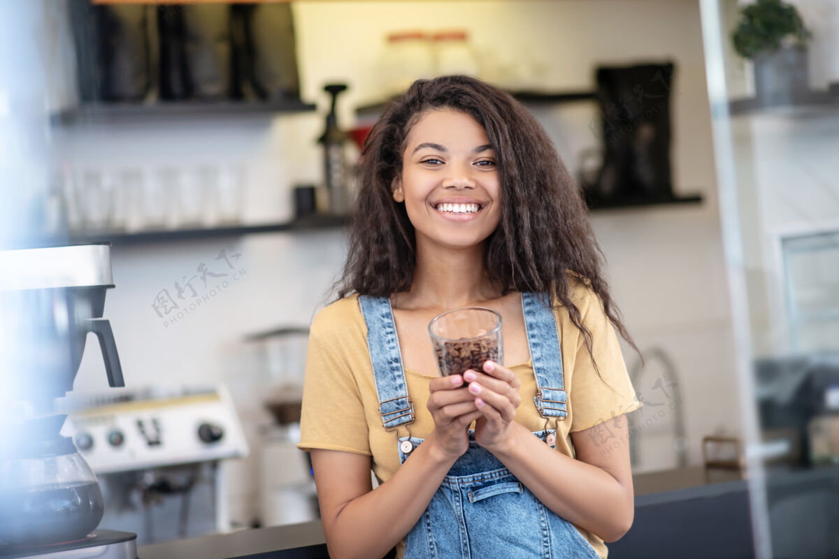 专家咖啡行家快乐一个留着黑色长发的女人 穿着休闲服 在咖啡馆的玻璃里放着一部分咖啡豆享受情绪千禧一代