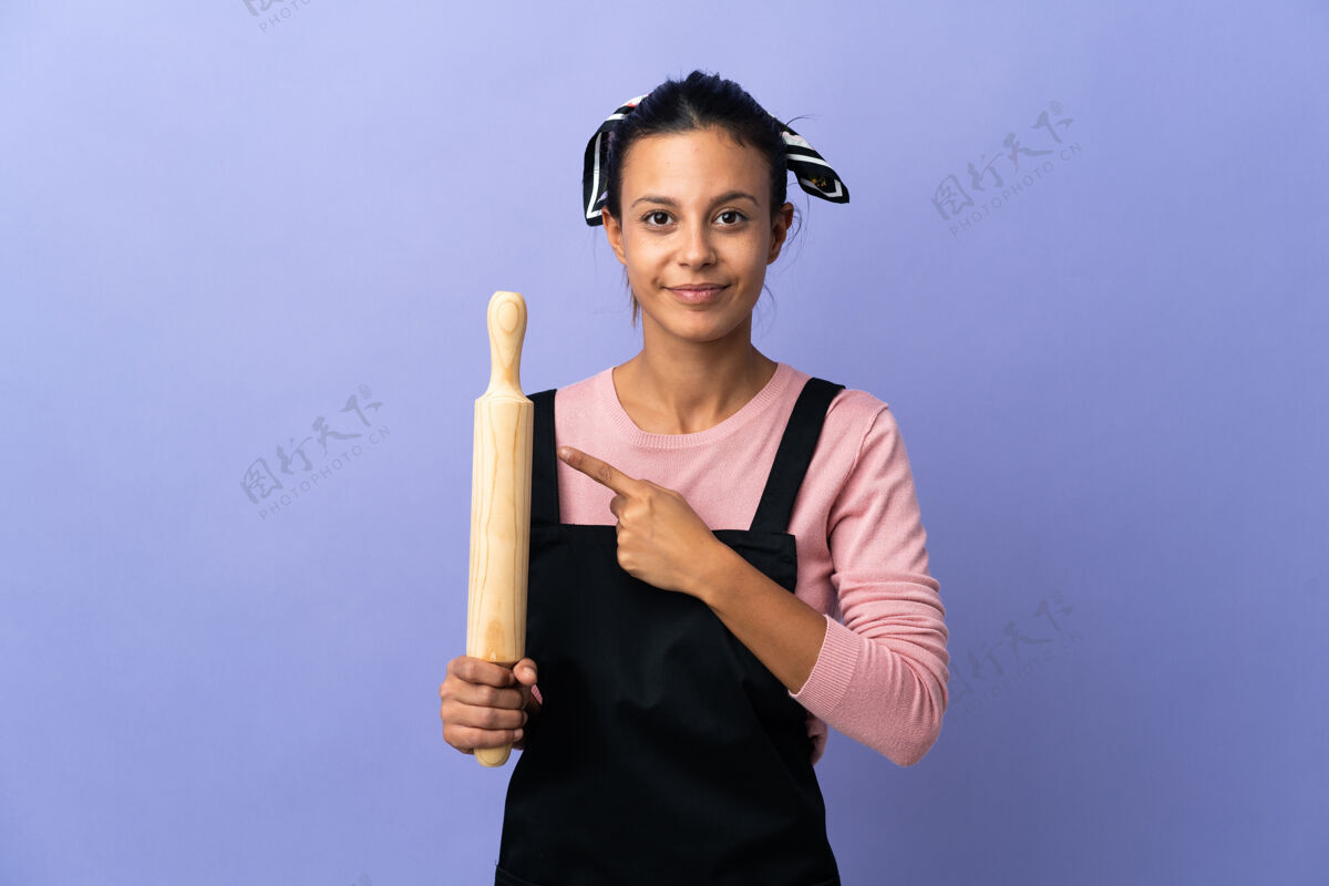 面包师身着厨师制服的年轻女子指着旁边赠送产品手右表情