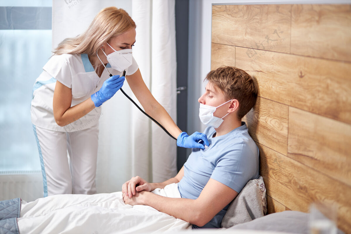 头痛专业女医生正在用喉镜听男性患者呼吸 家中卧床身患冠状病毒症状.covid-19.医学概念脸房子室内