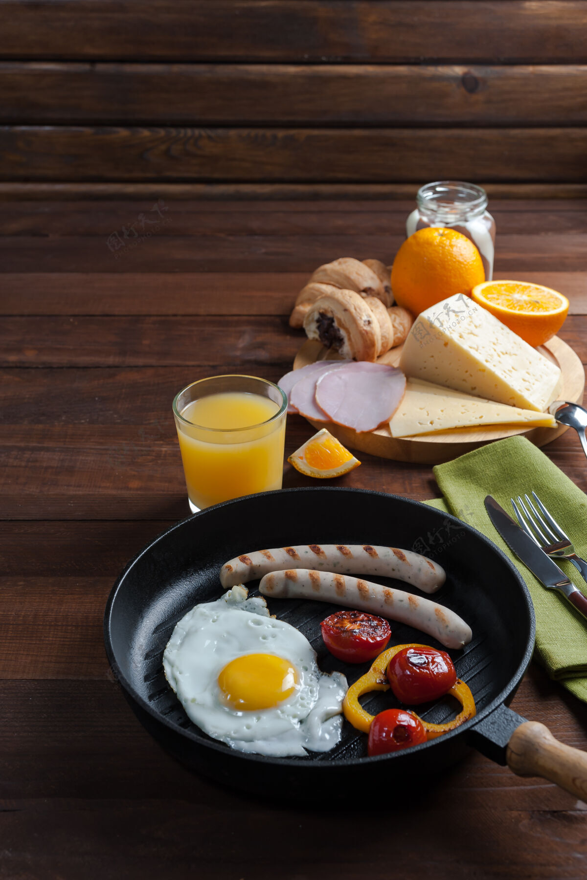 桌子香肠蔬菜炒鸡蛋潘早餐在木制的乡村木板上放着橘子汁和羊角面包 食物背景晚餐平底锅烤肉