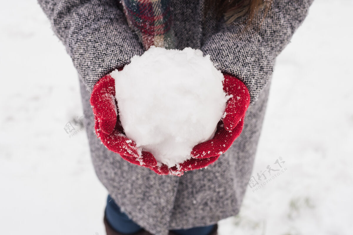 心戴着红色手套的女孩捧着雪 祝你圣诞快乐礼物猩红手