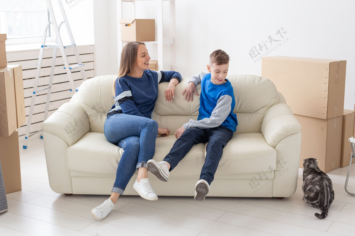 抵押满意快乐的白种人单身母亲和儿子愉快地交流讨论新房子的设计舒适建筑年轻