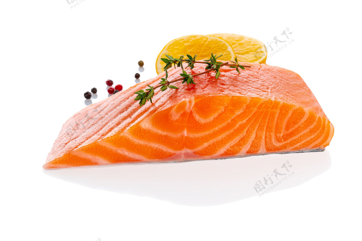 鱼新鲜生生三文鱼片牛排隔离在白色背景与调味料和柠檬 侧视图鱼片膳食配料