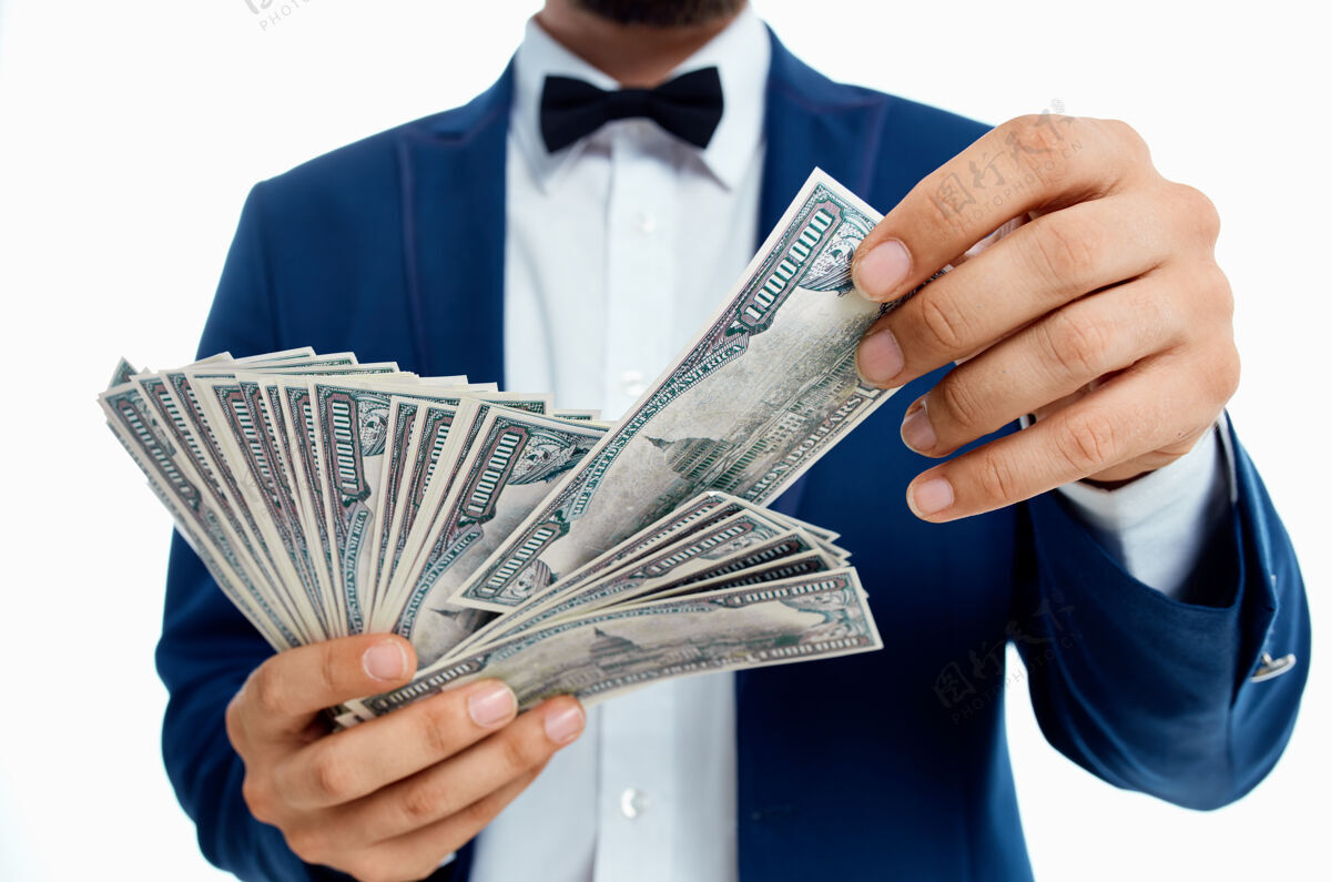 钱一个穿着蓝色夹克衫 手里拿着一沓钱的有钱人成人富人年轻