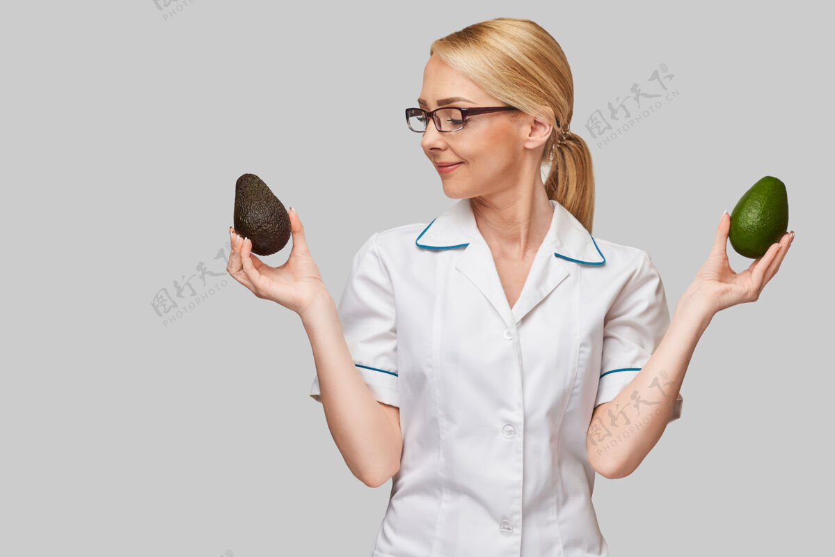制服营养师医生健康生活理念-持有有机鳄梨水果健康减肥女人