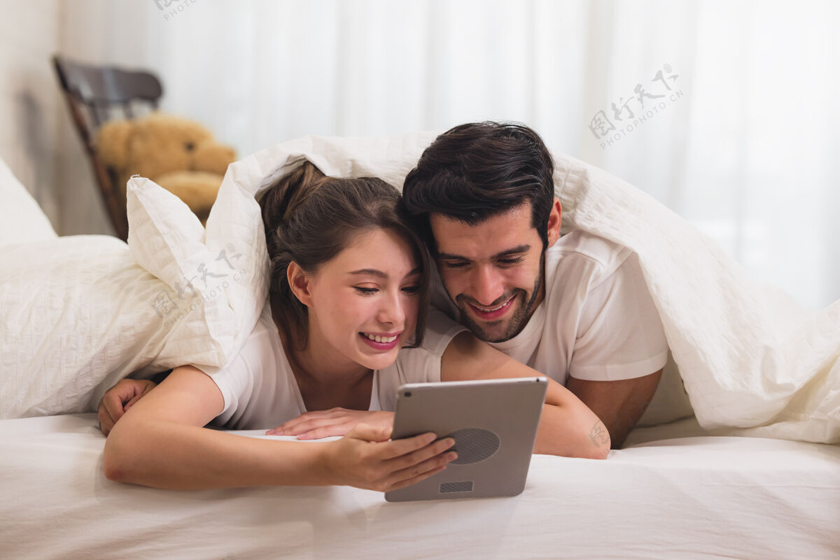 漂亮在床上看一些平板电脑上的东西 在卧室里放松网络空间女人床
