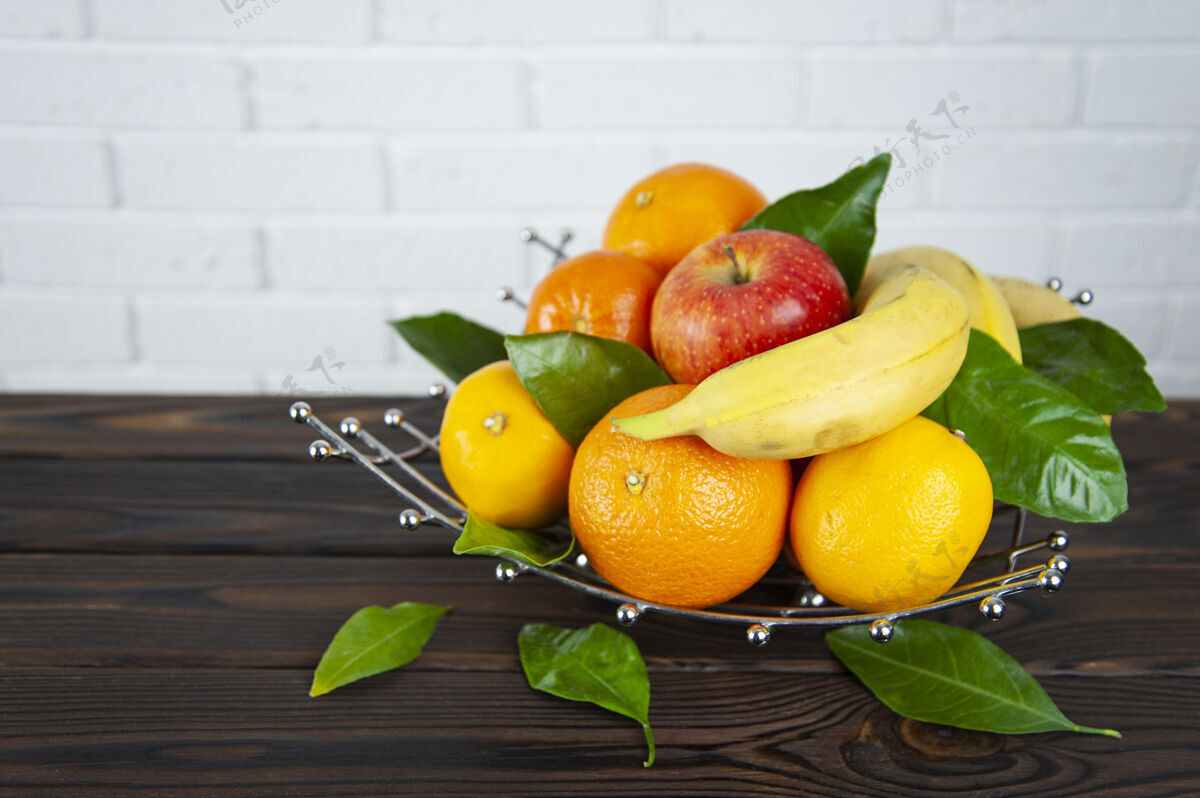 橙子各种水果放在木制表面的金属水果碗里苹果组成熟