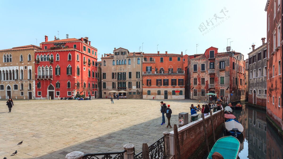 历史建筑船在威尼斯五颜六色的历史建筑之间的狭窄运河上地标度假历史