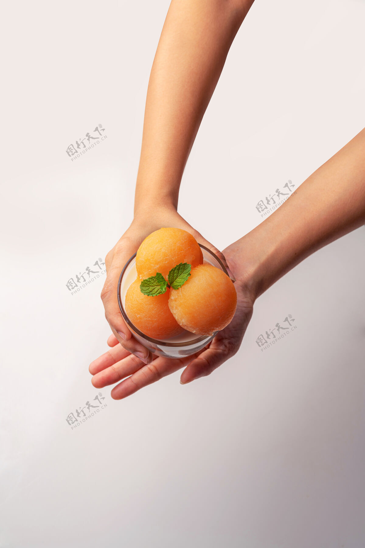 块黄瓜瓜被舀成圆球状 像冰激凌一样放进透明的玻璃杯里 上面浇上鲜奶 香甜可口生蔬菜健康