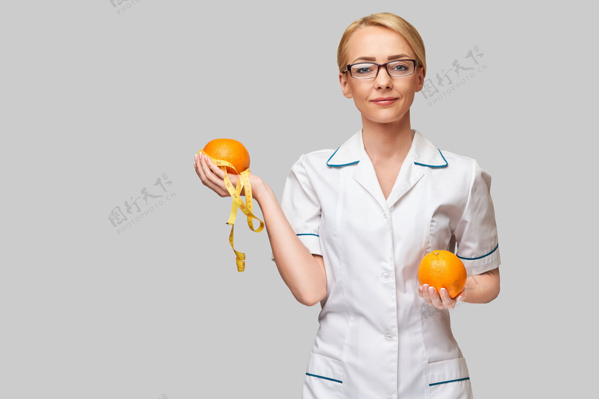 专业知识营养师医生健康的生活方式理念-拿着橘子水果和卷尺减肥保持营养师