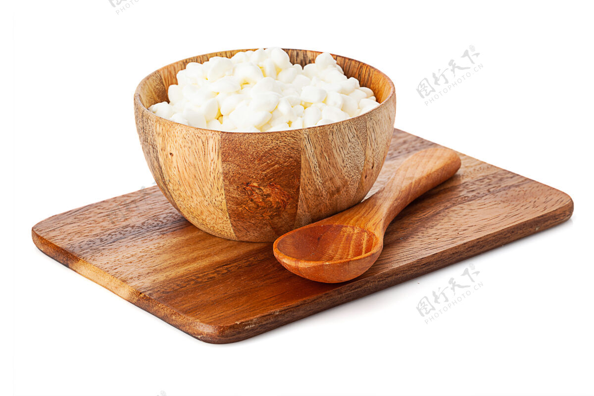 食物木盆 木盆上放着干酪和勺子隔离板在白色背景上甜乳制品白